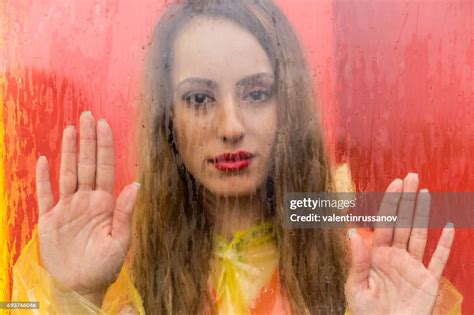 Sad Young Woman Looking Through Window On Rainy Day High Res Stock