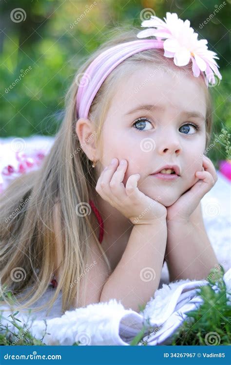 Милая маленькая девочка на зеленой траве Стоковое Изображение изображение насчитывающей