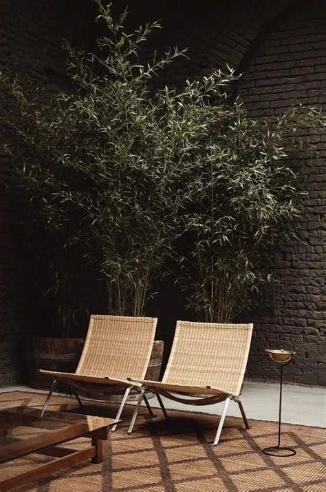 Two Lounge Chairs Sitting Next To Each Other In Front Of A Brick Wall