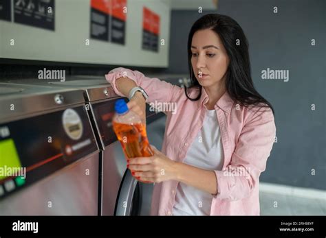Woman In Laundromat Showing Cleaning Detergent Stock Photo Alamy
