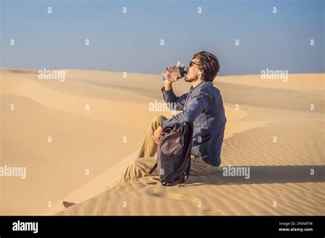 Man Feels Thirst And Drinks Water In The Desert Stock Photo Alamy