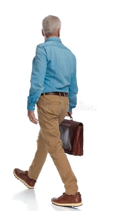 Back View Of Old Man In His 60s Holding Suitcase And Walking Stock