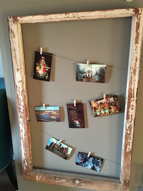 An Old Frame With Pictures Hanging On Clothes Pins