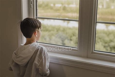 Boy Looking Through Window While Standing At Home People Dreaming