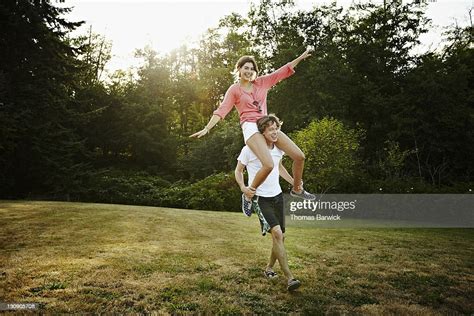 Young Woman Riding On Mans Shoulders Foto Stock Getty Images