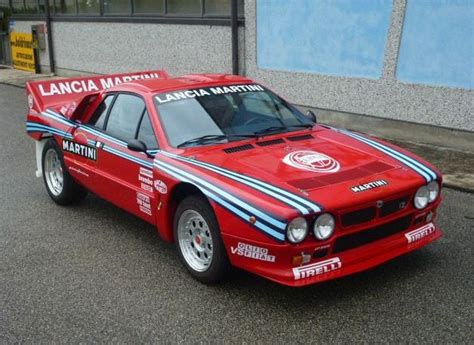 The Lancia Martini Racing Car Is Parked On The Street In Front Of A