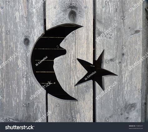 A Close Up Of A Moon And Stars Cut Out On A Rustic Weathered Wooden
