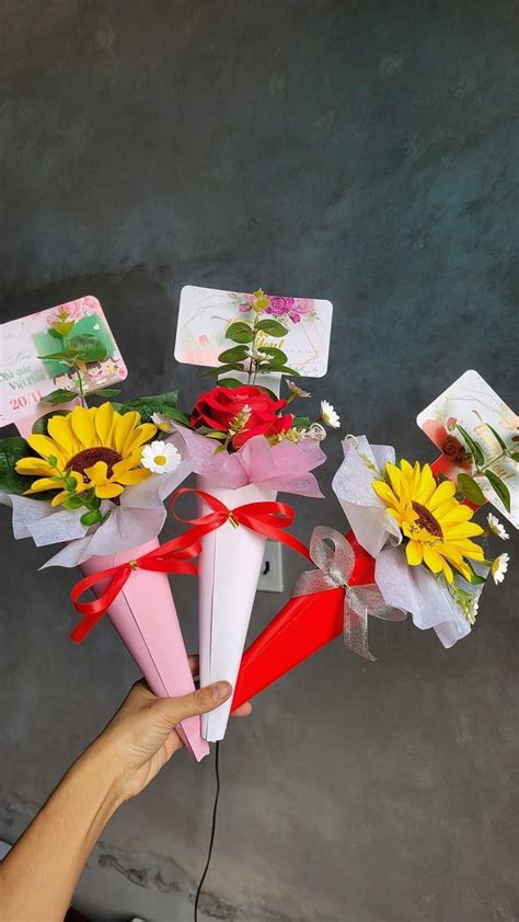 A Person Is Holding Some Flowers In Their Hand And There Are Cards On