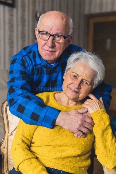 Portrait Of An Elderly Couple Caring Husband Standing Behind His