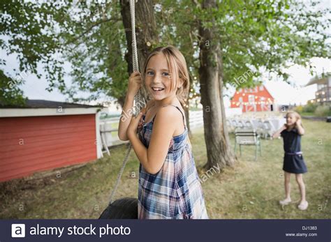 Portrait Of Smiling Girl Playing On Tire Swing Outdoors Stock Photo Alamy