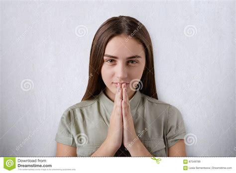 A Confident Young Girl With Beautiful Dark Eyes And Hair Praying With