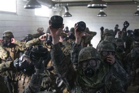 south korean and u s marines break the seal of their gas masks during the korean marine
