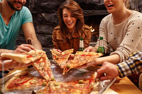 Laughing Friends Eating Pizza And Having Fun They Are Enjoying Eating