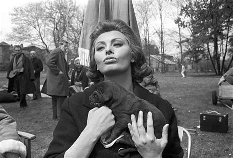 Sophia Loren Poses Sending A Kiss With A Dog In Her Arms During A Old