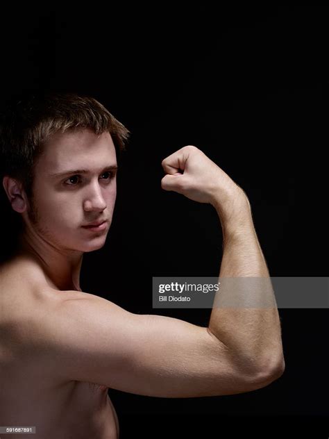 Young Man Flexing Bicep High Res Stock Photo Getty Images