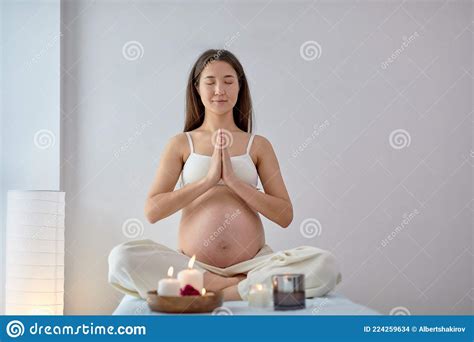 Pregnant Asian Woman Relax Doing Yoga Sitting In Lotus Position In Spa