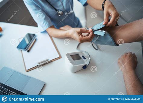 Female Doctor Checking Patient Blood Pressure In Clinic Stock Image