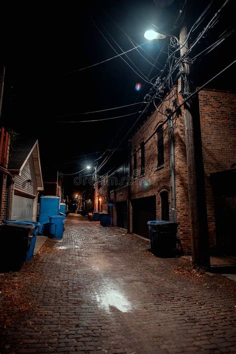 Dark And Eerie Urban City Cobblestone Brick Alley At Night Stock Photo