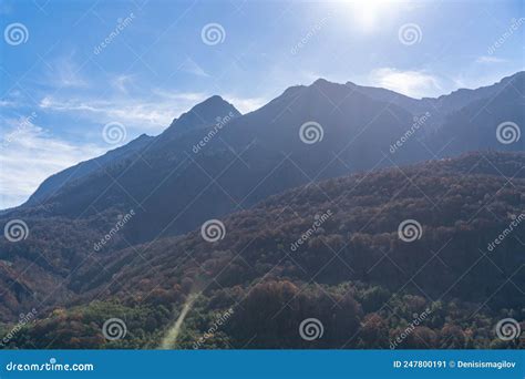 Hillside And Mountain Under Light Blue Sky Sun And Clouds Stock Image