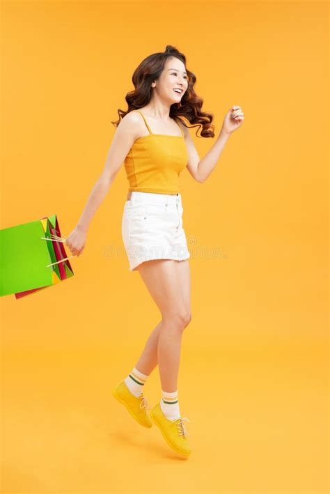Big Sales Girl Running With Shopping Bags Over Yellow Background Stock