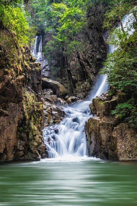 Waterfall Over Rock And Green Tree With Green Small Lake Stock Image