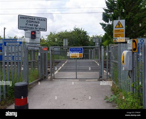 Gated Level Crossing With Signal Lights And Cyclists Dismount Sign