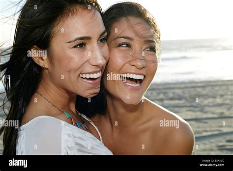 Women Smiling Together On Beach Stock Photo Alamy