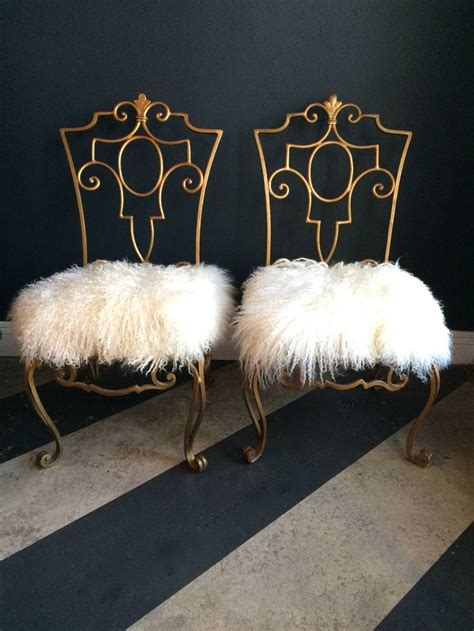 Two Chairs With White Fur On Them Sitting Next To Each Other