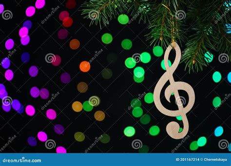 Wooden Music Note Hanging On Christmas Tree On Black Background With
