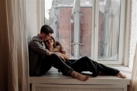 Premium Photo Young Couple Hugging And Kissing At Home In Loft Style