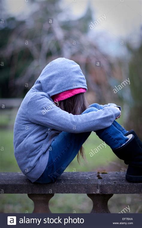 Sad Girl In Hoodie With Face Hidden Sitting Alone On A