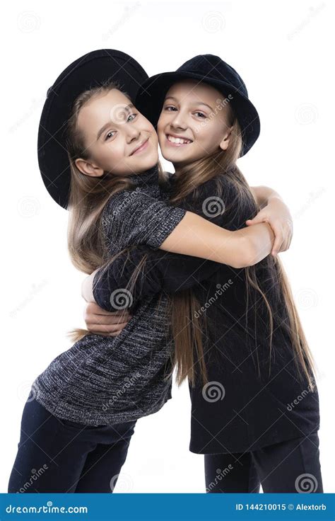 Two Cute Teenage Girlfriends Schoolgirls Wearing Turtleneck Sweaters Jeans And Hats Smiling