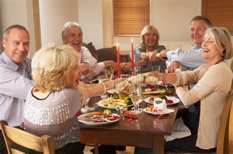 The dinner table is decorated with a christmas cracker for each person and sometimes flowers and candles. Elderly couples enjoying their ... | Stock image | Colourbox