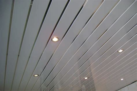 The Ceiling Is Covered With White Wood Slats And Light Bulbs Are