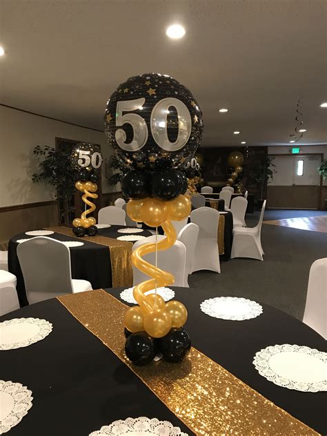 A Black And Gold 50th Birthday Party With Balloons In The Shape Of An