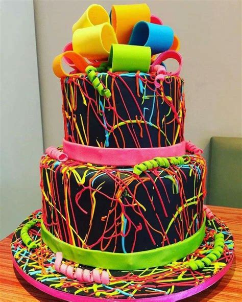 A Three Tiered Cake With Neon Colored Icing On The Top And Colorful
