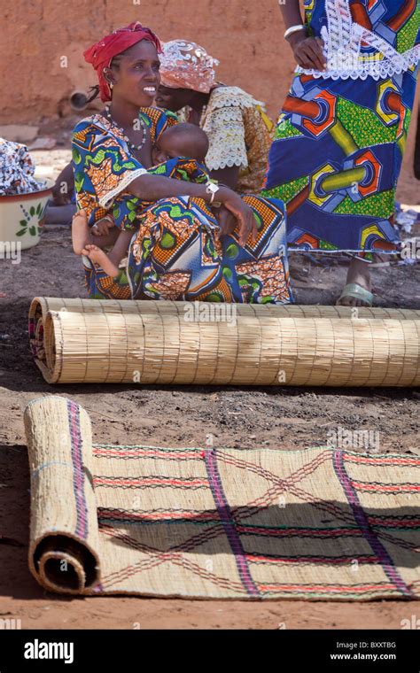 A Fulani Woman Sells Handwoven Straw Mats At The Weekly Market In Djibo