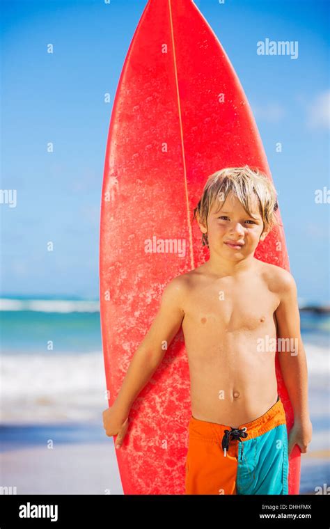 Young Surfer Happy Young Boy At The Beach With Surfboard Stock Photo