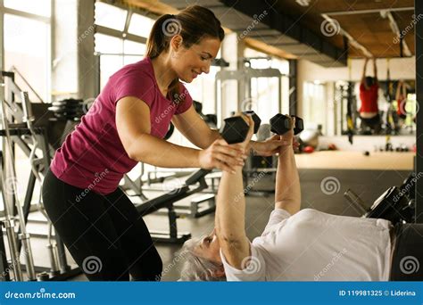 Personal Trainer Working Exercise With Senior Woman In The Gym Stock