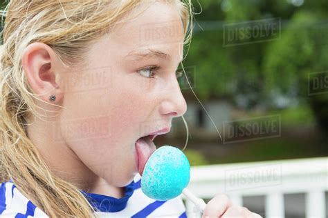 Tongue Of Caucasian Girl Licking Blue Lollipop Stock Photo Dissolve
