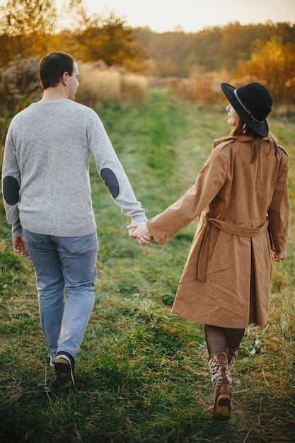 Premium Photo Happy Stylish Couple Walking Holding Hands In Autumn
