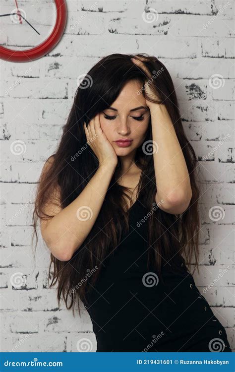 A Woman In A Black Dress Against A White Wall Stock Image Image Of Brunette Hair 219431601