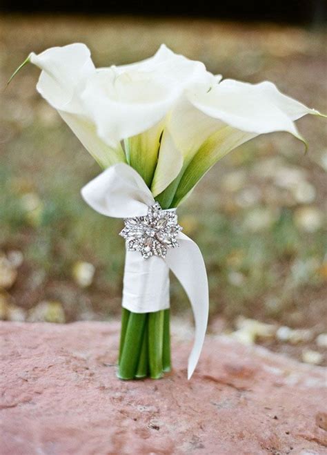 the brooch adds sparkle to this simple elegant white calla lily bouquet summer wedding