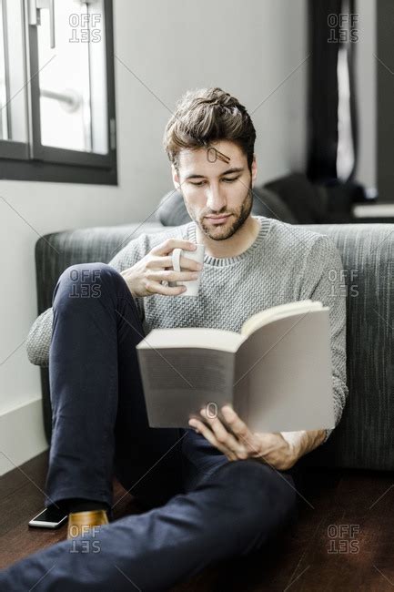 Young Man Reading Book At Home Stock Photo Offset