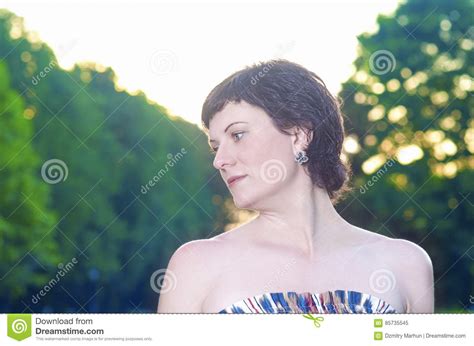 Portrait Of Smiling Caucasian Brunette Woman Posing Outdoors At Sunset