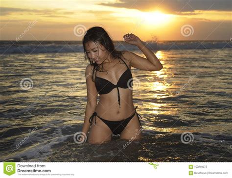 Het Sexy En Mooie Jonge Aziatische Vrouw Ontspannen Speels Bij Zonsondergangstrand Die Op Water
