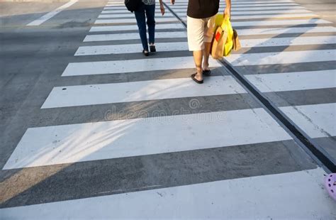 People Are Walking Across The Road At The Crosswalk Stock Image Image