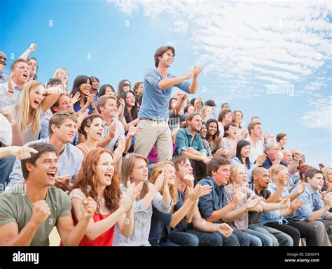 Man Standing And Clapping Among Cheering Crowd Stock Photo Alamy