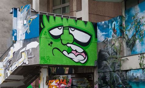A Green Monster Painted On The Side Of A Building Next To Some Stairs