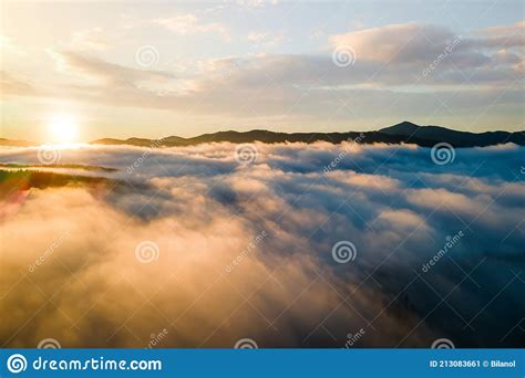 Aerial View Of Vibrant Sunset Over White Dense Clouds With Distant Dark